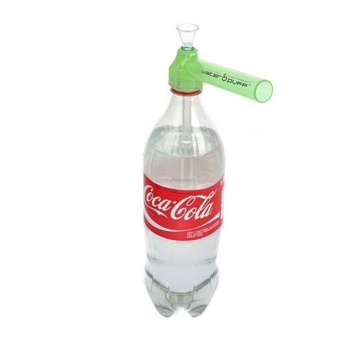 En transparent flaske med en slank, cylindrisk form og en let buet hals. Flaskens overflade er glat, og den har en blød, mat finish. Låget er skruelåg i en lys farve med en rund, flad top. Flasken prydes af et enkelt logo og en etikette i bunden med tekst i kontrastfarve.