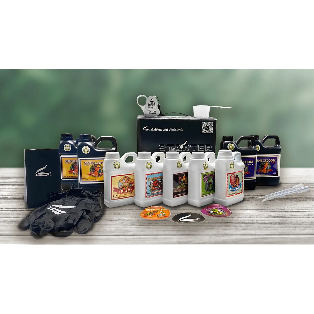 Et sæt af fire flasker præsenterer sig i forskellige størrelser, hver med en mat, farverig etiket. Etiketterne indeholder grafik af planter, tekst og symboler i nuancer af grøn, hvid og orange. Flaskerne har en glat plastoverflade med en sort, skrue-låg. Baggrunden er neutral og understøtter fokus på produkterne, der er arrangeret tæt sammen.