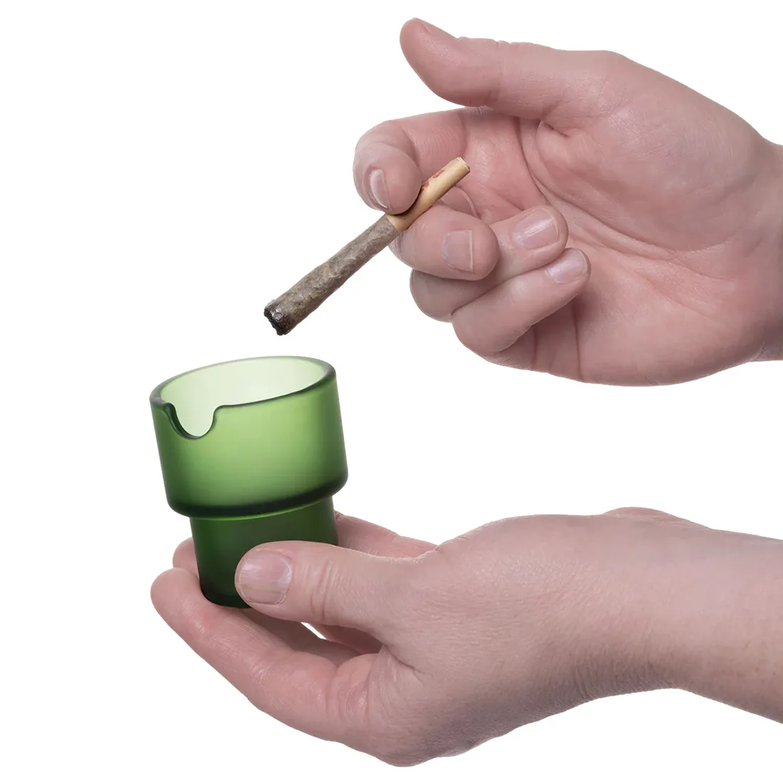 Blomsterkrukker i grøn og hvid keramik pryder overfladen med en glat, mat finish. Den grønne krukke har en rund form og en let skrå kant, mens den hvide krukke er mere cylindrisk med en markant, glat overflade. Begge krukker viser en minimalistisk stil, der fremhæver deres enkle, moderne design. Der ses ikke synlige mønstre eller dekorationer.