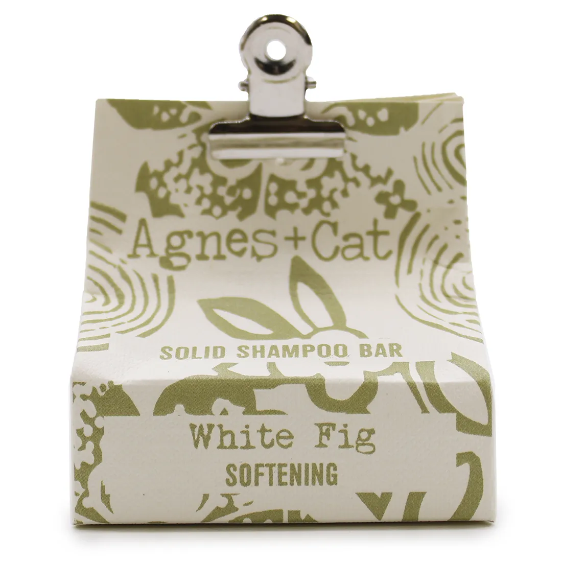 En solid shampoobar i en rund form, med en glat, hvid overflade og let satinagtig tekstur. Baren har en let skinnende finish og er prydet med en indgraveret kattefigur. Den er placeret på en neutral, lys baggrund, der fremhæver dens enkle og minimalistiske design. Ingen synlige emballager eller yderligere elementer er til stede.