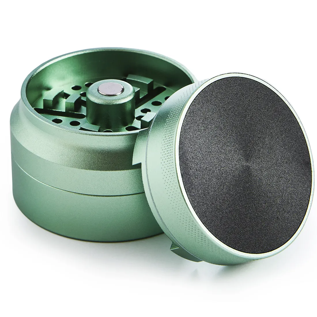 En grøn grinder med en diameter på 55 mm og en højde på 63 mm præsenterer sig med en glat, blank overflade, der reflekterer lys. Grinderen har en flad top og en let buet bund, med en gribeflade langs kanten for bedre håndtering. Mønstret på overfladen er enkelt, hvilket giver et minimalistisk udtryk.