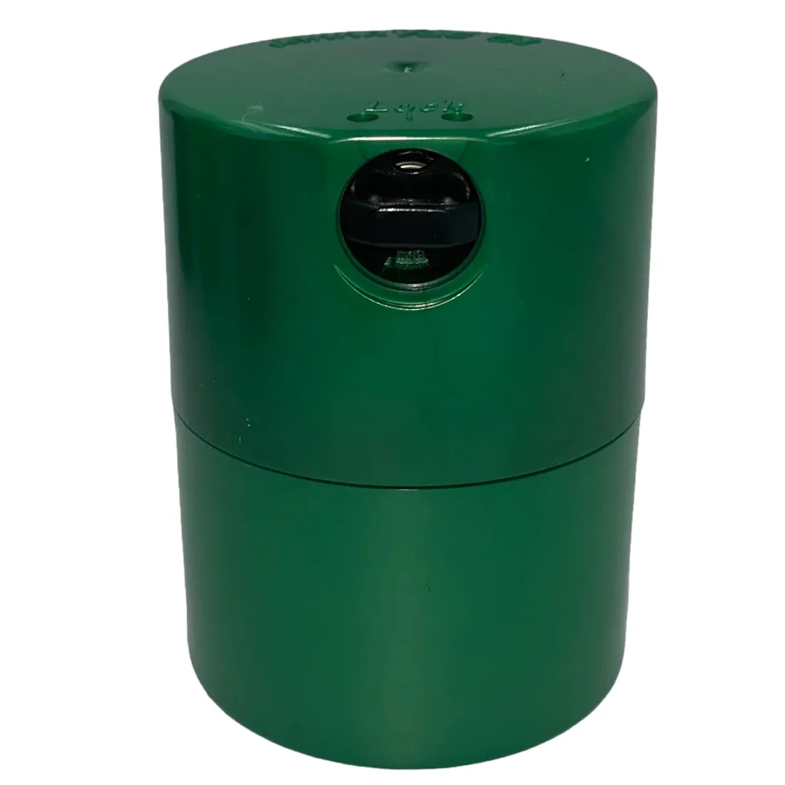 En mørkegrøn, cylindrisk beholder med en glat overflade og en skruehætte. Beholderens øverste del har en let skråning, der afsluttes med en flad kant. Hætten er også mørkegrøn og har et diskret mønster. På siden er der en tydelig, hvid tekst, der angiver volumen, samt et symbol for lufttæthed.