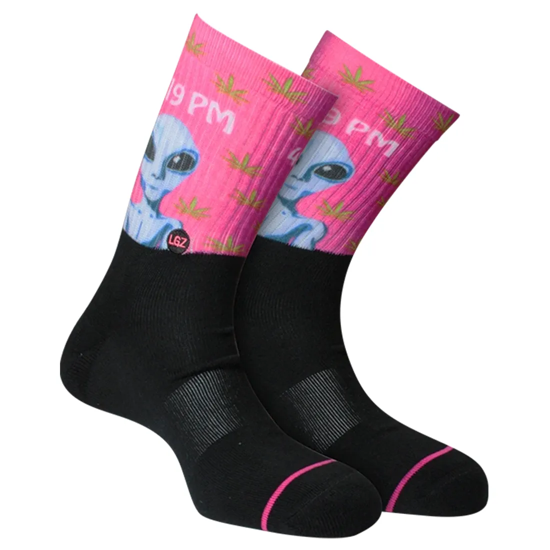 Crew-sokker i en dyb sort farve med et farverigt mønster af aliens og stjerner. Mønsteret præsenterer detaljerede, cartoon-lignende figurer med grønne og lilla nuancer, der står i kontrast til den mørke baggrund. Sokkerne har en ribbet struktur ved åbningen og en glat tekstur på selve sokken, hvilket giver et moderne og legende udtryk.