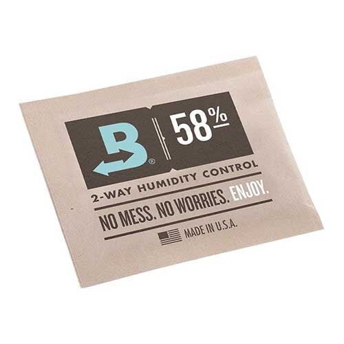 En lille, firkantet pakke med en hvid og transparent plastoverflade prydet med en blå og grå etiket. Etiketens tekst er i sort og indeholder information om produktet, herunder en beskrivelse af fugtighedsregulering. Den indre pakke synes at indeholde et fugtighedsholdende materiale, synligt gennem det gennemsigtige område. Formen er kompakt, og størrelsen er håndholdt.