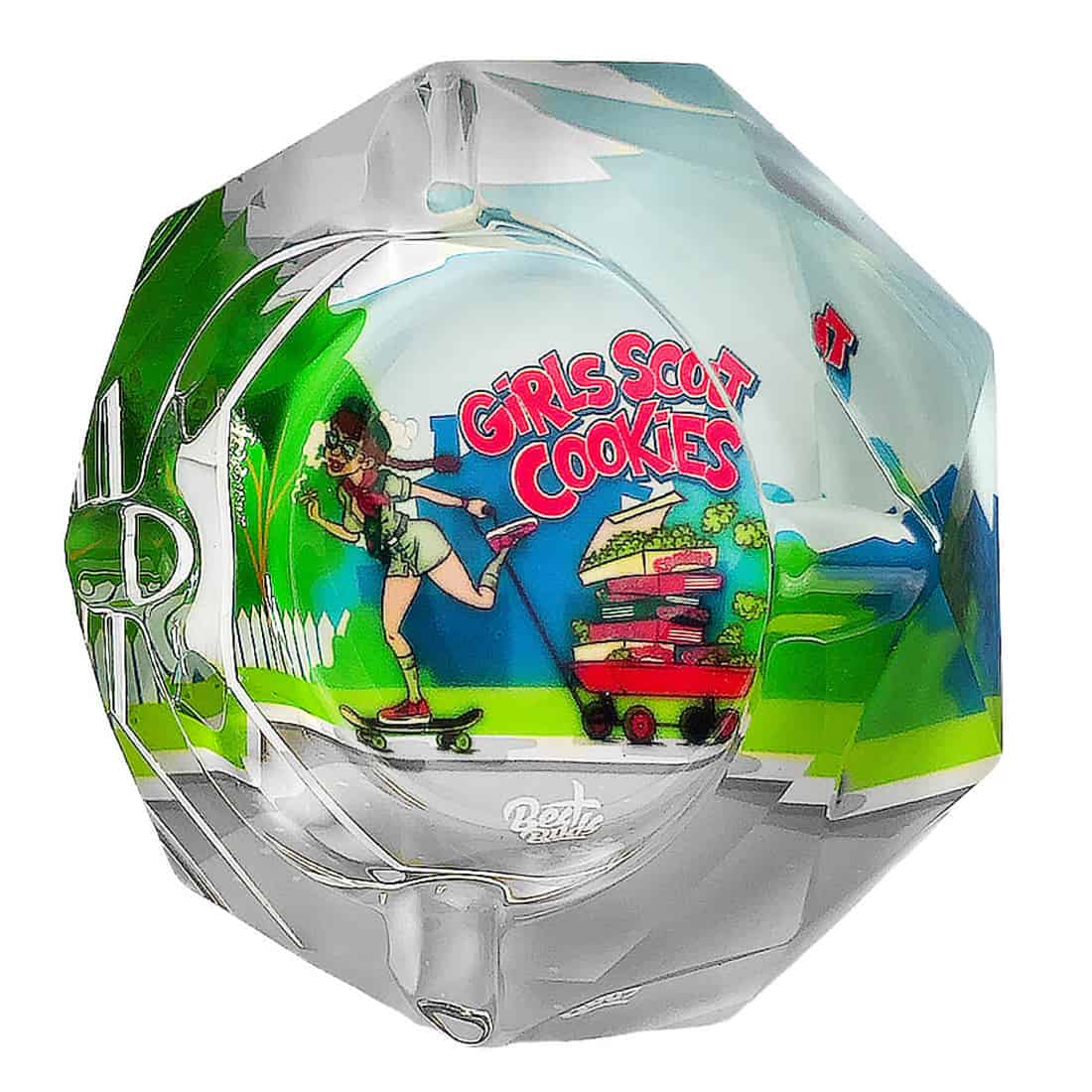 En klar, krystalagtig askebæger med en glat overflade og skarpe kanter. Den har en rund form med en dyb skål i midten, der er omkranset af en lav, bred kant. Askebægeret prydes af indgraverede mønstre, der skaber et elegant, reflekterende udtryk. Farven er gennemsigtig med lette nuancer af blå og grøn, der fanger lyset.