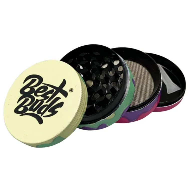 En lille, rund grinder i en blød pastelgrøn farve prydet med et farverigt mønster af frugter som citroner og bær. Overfladen har en glat tekstur, mens kanterne er let skrå. Den har en enkelt, centralt placeret knap på toppen. Grinderens diameter måler 50 mm, hvilket gør den kompakt og let at håndtere.