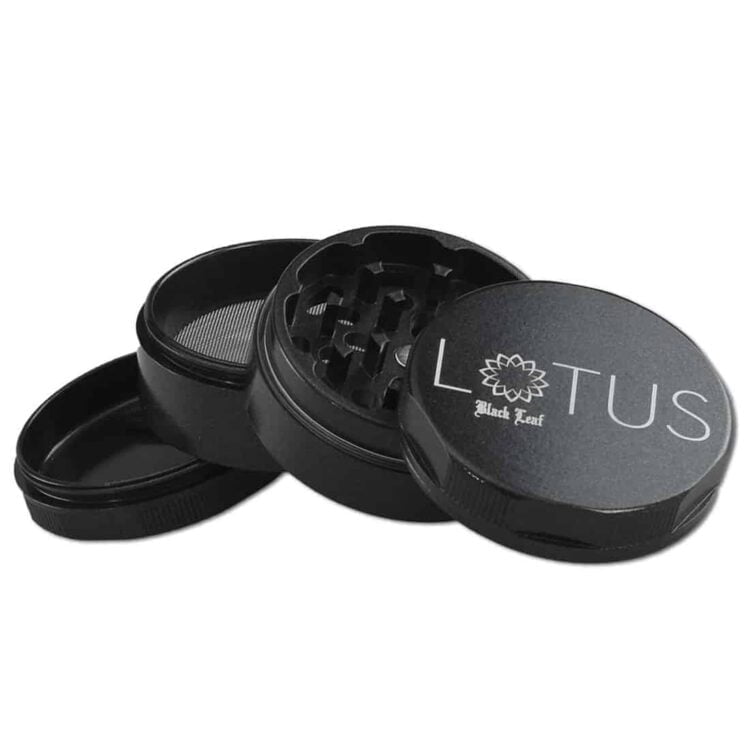 En sort kvadratisk krydderikværn med en diameter på 53 mm præsenterer sig med en mat overflade og let buede kanter. Den øverste del har en skarp, sølvfarvet metalknap til åbning. Indersiden rummer en skarp tandstruktur, der er designet til effektiv kværning. Mønstret af blade er til stede på låget, hvilket tilføjer en dekorativ detalje.