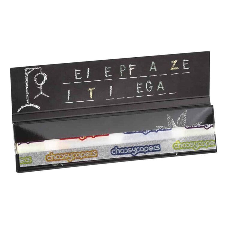 Et produktbillede af Choosypapers - ICH DARF NICHT KIFFEN King Size Slim rullepapir foran en tavlestil-opgave med teksten "ELEPHANT IN TEA" delvist løst i baggrunden.