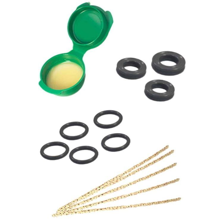 Dynavap Dynakit til vedligeholdelse består af en række værktøjer i rustfrit stål og plastik. Værktøjerne har en mat overflade med forskellige former, herunder en skruetrækker, en pensel og en nål. Farverne spænder fra sølv til sort, og der er detaljer som en lille opbevaringsæske. Hver del er omhyggeligt placeret i en ordnet sekvens.