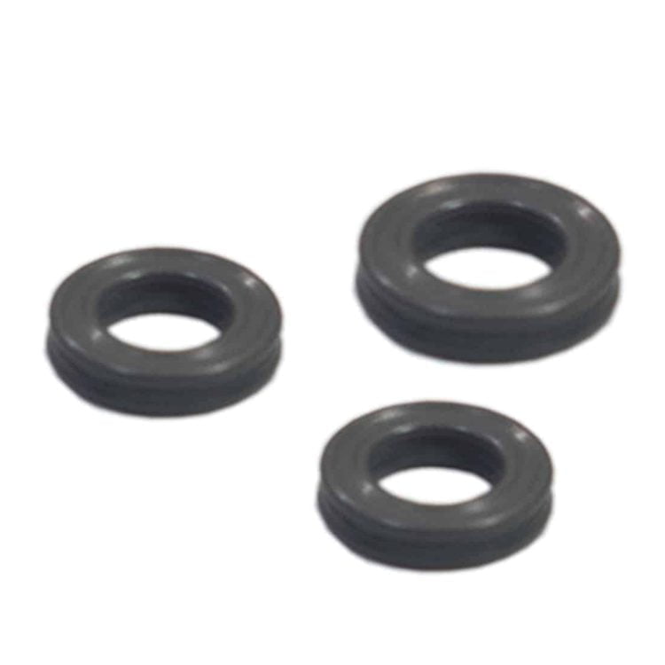 Et sæt O-ringe i forskellige størrelser præsenteres i en klar plastpose. O-ringe er fremstillet af sort gummi med en glat overflade, der giver en tæt forsegling. Posens lukning er en enkel tryklås. Baggrunden er hvid, hvilket fremhæver de sorte O-ringe, der ligger fladt i posen.