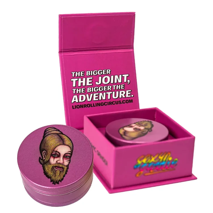 En keramisk kværn med en diameter på 50 mm præsenterer sig i en glat, blank overflade, der skinner i lys. Den har en rund form med en skridsikker kant. Farven er dybgrøn med indgraverede detaljer, der tilføjer et dekorativt præg. Kværnen har en metalknap i toppen og en finmasket si, som afslutter det funktionelle design.