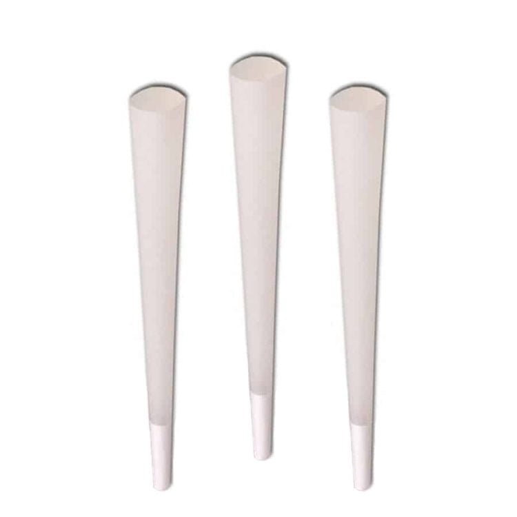 Tre koniske objekter præsenteres i forskellige farver: en lys grøn, en dyb blå og en varm rød. Hver kegle har en glat overflade, som reflekterer lys og skaber bløde skygger. De står stabilt på en flad, neutral baggrund. Keglerne har ensartede, præcise former og er placeret med en vis afstand imellem, hvilket giver en harmonisk komposition.