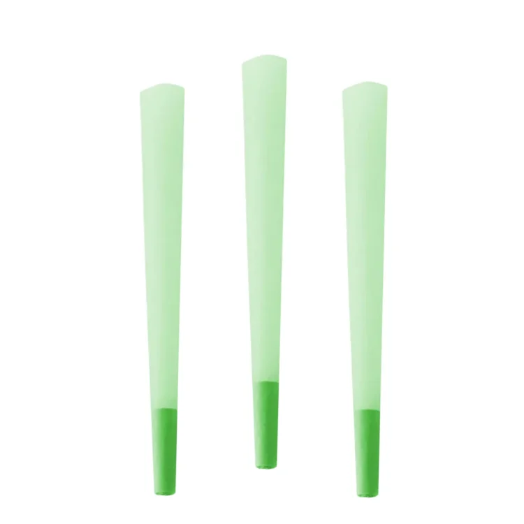 Tre grønne kegler i forskellige nuancer pryder en lys baggrund. De har en glat, skinnende overflade og er fremstillet af plast. Keglerne varierer i størrelse og står stabilt med en bred bund. Deres koniske form er tydelig, og de har ingen synlige mærker eller teksturer, hvilket giver dem et enkelt og rent udtryk.