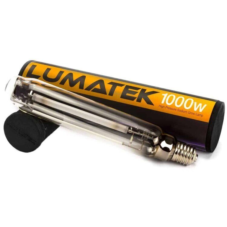 En stor, cylindrisk lysarmatur præsenterer sig i en metalisk sølvfarve med en glat overflade. Øverst er der en reflekterende skærm, der er let buet, hvilket optimerer lysfordelingen. Under skærmen findes en kraftig HPS-lampe med en gylden glød. Armaturet har to kraftige kabler, der hænger ned, og en solid monteringsbeslag i den ene ende.