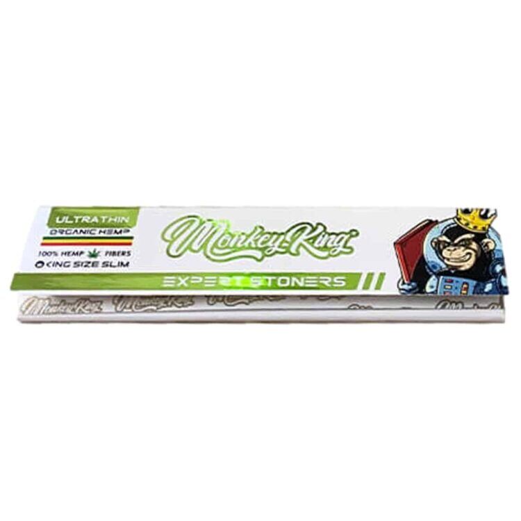 Billedet falder hovedsageligt under kategorien "cannabisforbrugere og rygere", da det specifikt appellerer til personer, der anvender rullepapir til at ryge. Her er et forslag til en passende alt-tekst: "Emballagebillede af The Monkey King - Expert Stoners Hemp Ultra Thin King Size Slim rullepapir. Den hvide pakke prydes af en tegneserie-abe med krone, målrettet mod stilbevidste cannabisbrugere, der værdsætter kvalitet.