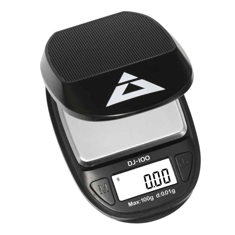 En digital vægt med en flad, rektangulær platform i metal pryder overfladen. Vægten har en klar LCD-skærm, som viser tal i sort skrift. Knappen til nulstilling er placeret foran, mens vægtens ben er robuste og skridsikre. Farverne domineres af sølv og sort, hvilket giver et moderne og stilrent udtryk.