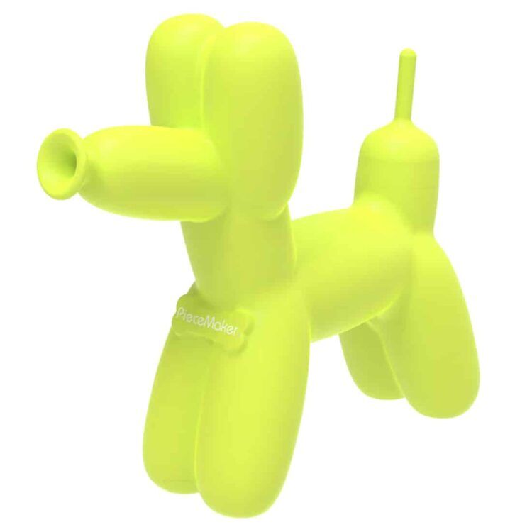 En stor, rund, gul skål pryder midten af kompositionen. Skålen har en glat, skinnende overflade, der reflekterer lys. Den er omgivet af en række små, farverige kugler i nuancer af blå, grøn og rød. Baggrunden er lys og neutral, hvilket fremhæver de levende farver og former i skålen og kuglerne.