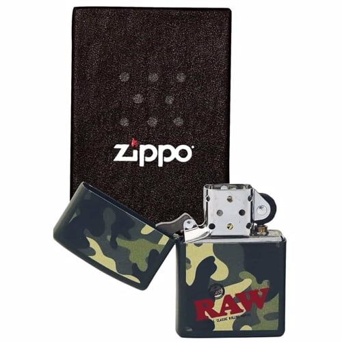 En camouflage zippo- lighter pryder overfladen med et mønster i nuancer af grøn, brun og sort. Den matte finish giver en let tekstur, der kontrasterer med den glatte metalramme. Lighterens hængsel og låsemekanisme er i rustfrit stål, hvilket tilføjer et industrielt præg. En lille, rund knap pryder toppen, der adskiller sig fra det overordnede design.