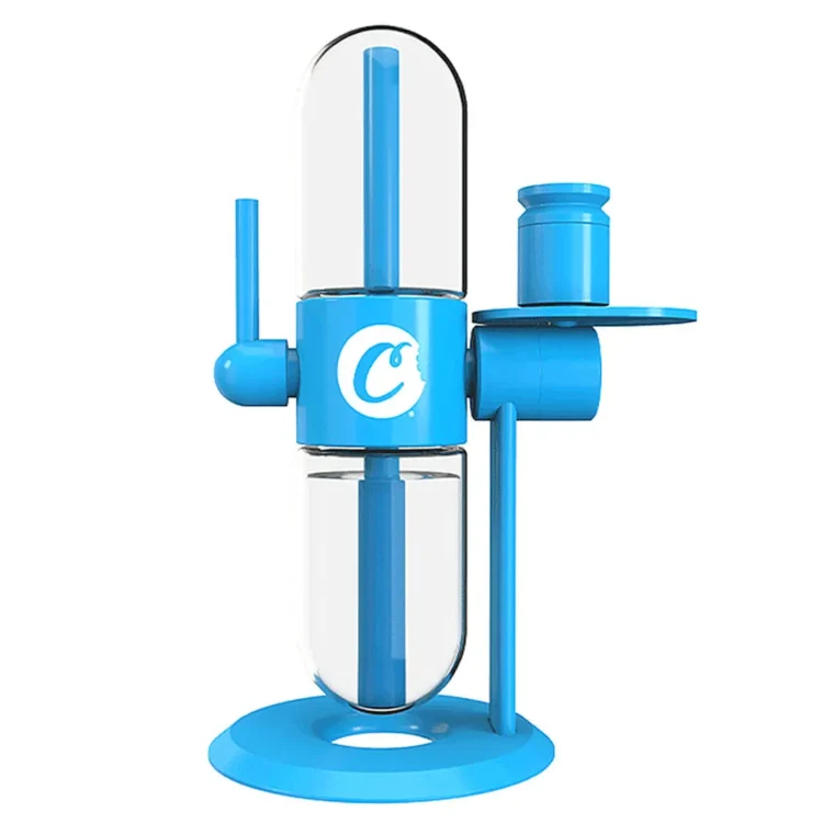 Stundenglass gravity hookah præsenterer en slank, cylindrisk krop i klart glas med en glat overflade, der fremhæver de indre farver. Den øverste del afsluttes med en metalkrone i børstet stål, der glitrer. Designet omfatter en hvid silikoneslange, der bølger elegant. Basen er udstyret med en fyldig, rund skål til tobak, der er dekoreret med detaljerede mønstre.