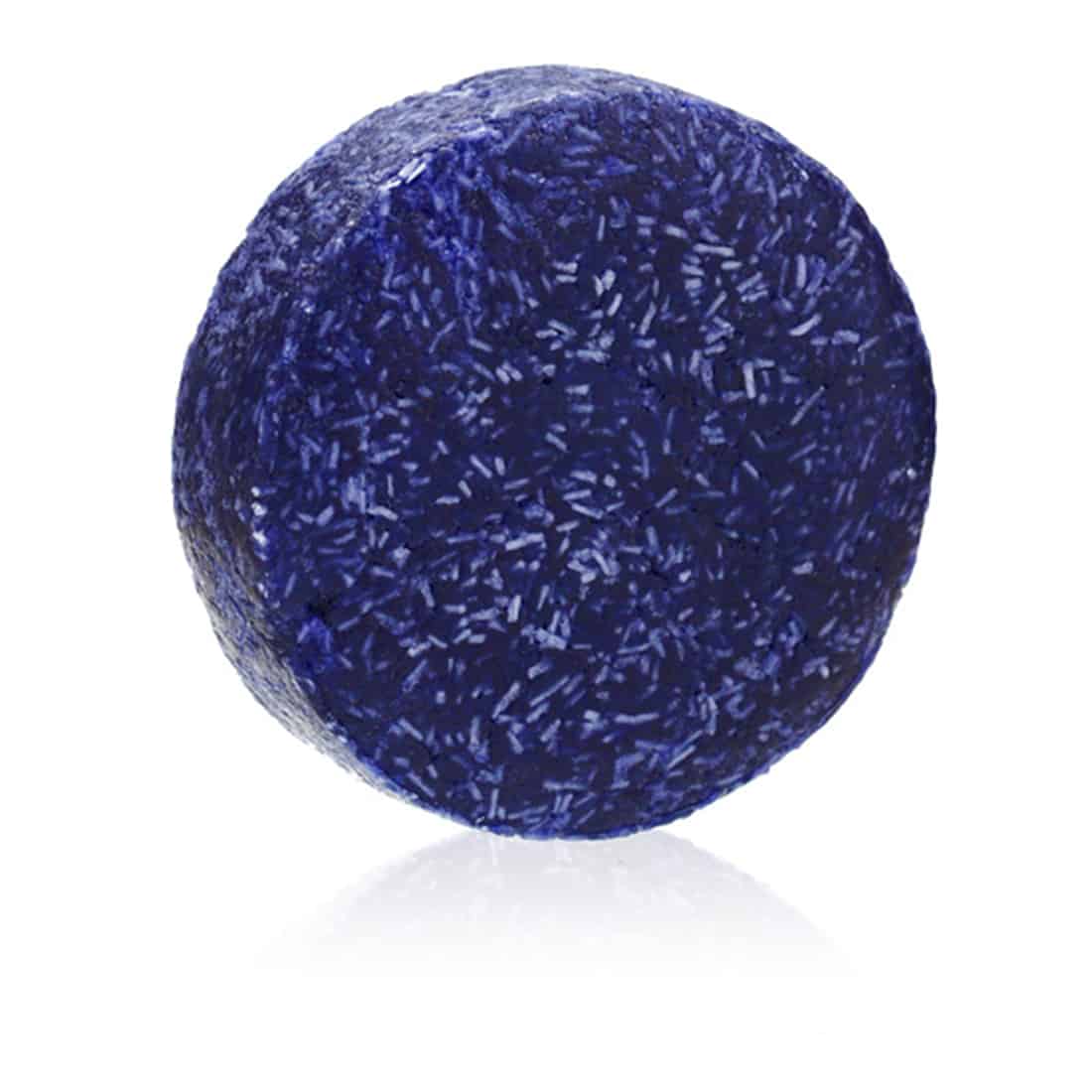 En solid shampoo i en oval form, vejer 60 gram, præsenteres i en dyb sort farve med en let glans. Overfladen har en fin struktur med små uregelmæssigheder, der giver en naturlig følelse. Ingen synlige indgraveringer eller skrift er til stede, hvilket understreger det minimalistiske design. Shampooen ligger på en lys overflade, der kontrasterer med den mørke farve.