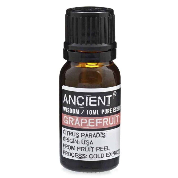 En lille, klar glasflaske med en sort skruelåg indeholder en æterisk olie. Flasken har et rektangulært design med en etiket i bløde farver, der angiver produktets navn og indhold. Etiketten prydes af grafiske elementer og tekst i en elegant skrifttype. Den gennemsigtige væske har en let gylden farvetone, der skinner svagt i lyset.