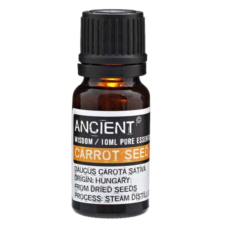 En mørkeblå glasflaske med en skruelåg i sølvfarvet metal, indeholdende 10 ml æterisk olie. Etiket med grønne og brune nuancer pryder flaskens front, hvor teksten angiver "Gulerodssfrø" og "Æterisk olie" i tydelige skrifttyper. Flaskens overflade har en glat finish, og lyset reflekteres svagt fra metal-låget. Flasken står på en neutral overflade.