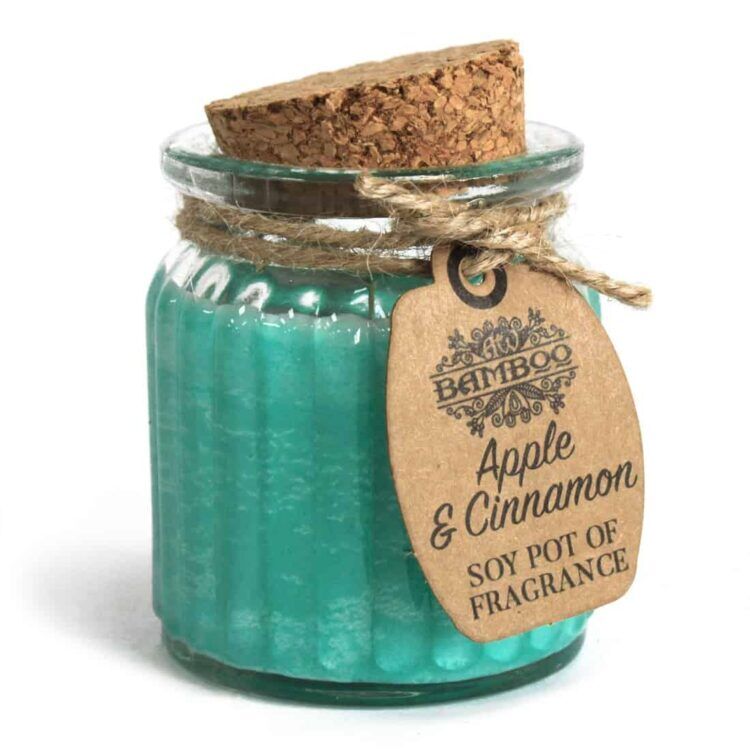 En rund lysestage i bambus med en glat, naturlig overflade pryder toppen. Indeni er der et hvidt sojavaxlys, der har en ensartet struktur og blød glød. Den mørkebrune bund af bambus fremhæver lysets farve, mens en lille tekstur kan ses på bambusoverfladen. Lysestagen står på en flad, lys overflade.