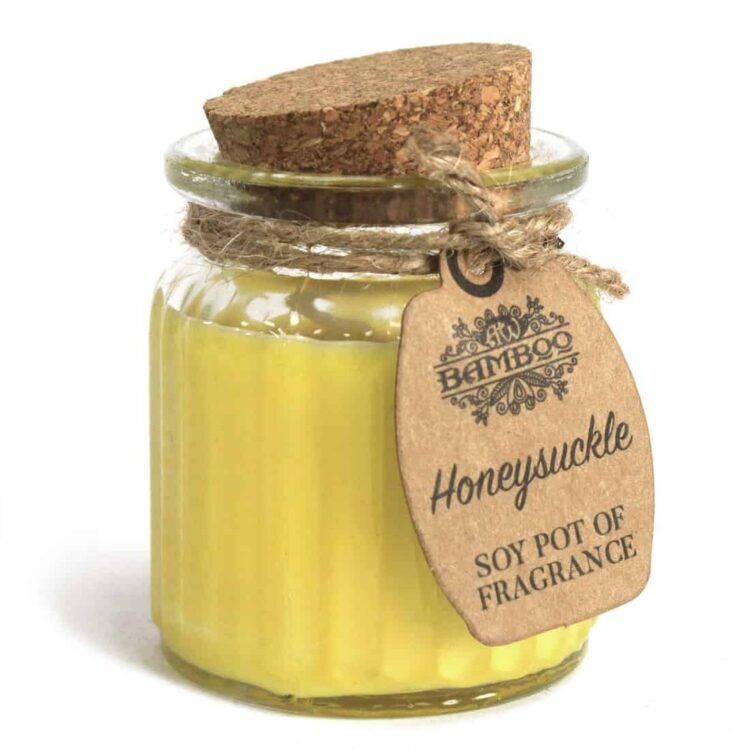 En lysestage fremstillet af bambus med en cylindrisk form og en naturlig, let bølget tekstur. Den indeholder et lys lavet af sojavoks med en hvid farve. Øverst er en lille, rund åbning, hvor lyset stikker op. Overfladen af bambus er ubehandlet, hvilket giver et rustikt udtryk, mens lysrefleksionen fra sojavoksen skaber en blød glød.