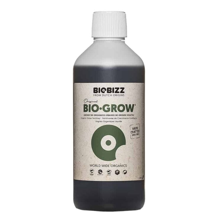 En transparent flaske med en brunlig væske. Flaskens form er cylindrisk, med en smal hals og en skruelåg i sort plast. Etiket i grøn og hvid med sort tekst præcist placeret på flaskens midte. Etiketten inkluderer et logo samt information om indhold og anvendelse. Flasken har en kapacitet på 0,5 liter.