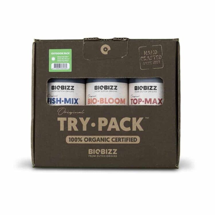 Tre små, firkantede pakker i forskellige farver pryder billedet. Hver pakke har en mat overflade med tydelig tekst i kontrastfarver. Den første pakke er grøn, den anden er brun, og den tredje er orange. Alle pakker har en illustrativ grafik, der viser planter. De er placeret på en neutral, lys overflade, hvilket fremhæver farverne.