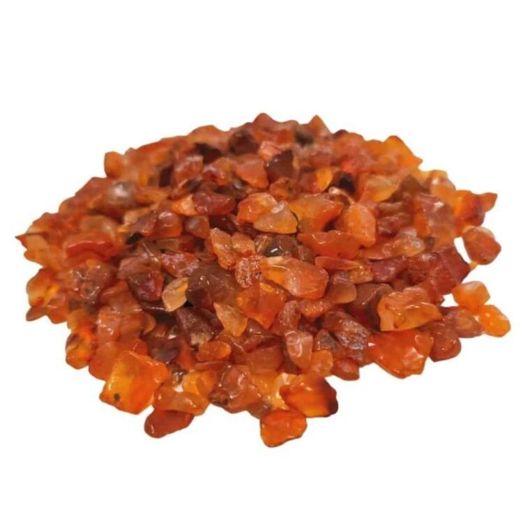 Runde, flade carnelian ædelsten chips i nuancer af orange, rød og brun pryder overfladen. Stenene har en glat, poleret tekstur, der skaber en lysreflekterende effekt. Chipsene varierer i størrelse og form, hvor nogle er mere uregelmæssige end andre. En let glans afslører deres mineraliske oprindelse, og de er præsenteret i en lille, gennemsigtig beholder.