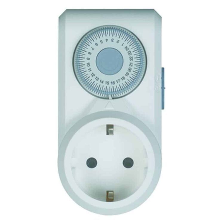 En mekanisk timer præsenterer sig i en cylindrisk form, domineret af en hvid plastikhus og en klar glasfront. Uret har en sort visuel skala med minutinddelinger, der strækker sig fra 0 til 60. En stor, grå drejeknap findes centralt, med en tydelig hvid pil, der angiver den valgte tid. Timerens bund har fire små gummifødder.