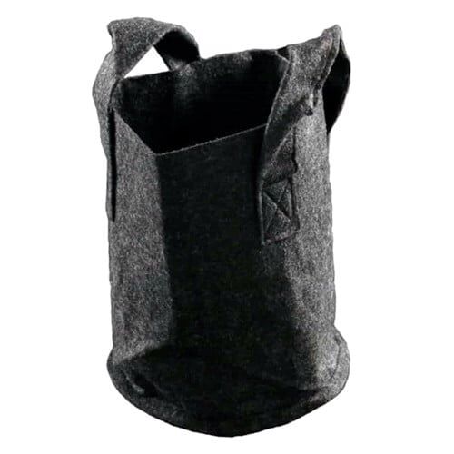 En rund potte i terracotta farve med en glat overflade pryder midten af kompositionen. Potten har en kapacitet på 3-8 liter og er udstyret med en tekstilbeklædning, der har et let struktureret mønster. Den nederste del er åben for dræning. Farverne er naturlige og jordnære, hvilket giver et rustikt udtryk.