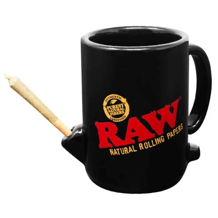 Koppen er fremstillet af keramisk materiale med en glat overflade. Den har en hvid baggrund prydet med farverige, grafiske elementer i nuancer af grøn, orange og sort. Teksten "Wake Up and Bake Up" er trykt i en legende skrifttype, der skaber kontrast til den lyse baggrund. Hanken er buet, hvilket giver et ergonomisk greb.