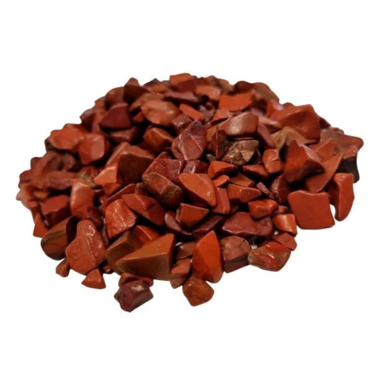 Røde jasper chips præsenteres i en tæt, uregelmæssig form med glatte overflader, der reflekterer lys. Farven varierer fra dyb rød til mørkere nuancer med subtile brunlige åretegninger. Chipsene er små og skarpe i kanterne, hvilket giver dem en organisk karakter. De ligger løst i en skål eller beholder, hvilket fremhæver deres naturlige skønhed og variation.