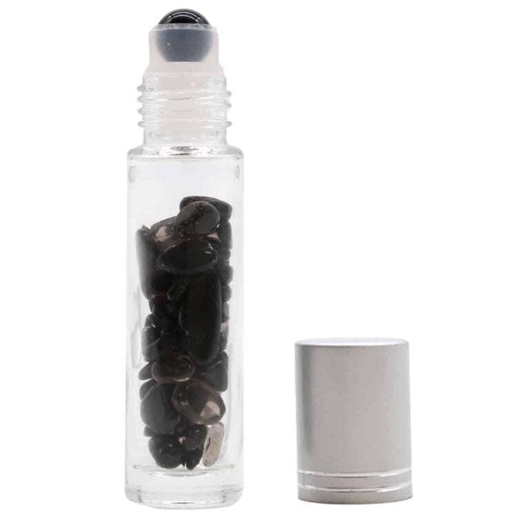 En sort rollerflaske fremstår med en glat, mat overflade og en rund, let skrå form. Flaskens hals er forsynet med en klar, glaskugle-applikator. Den sorte farve står i kontrast til den transparente applikator, hvilket skaber en enkel og elegant æstetik. Flaskens bund er flad, hvilket giver stabilitet ved placering.