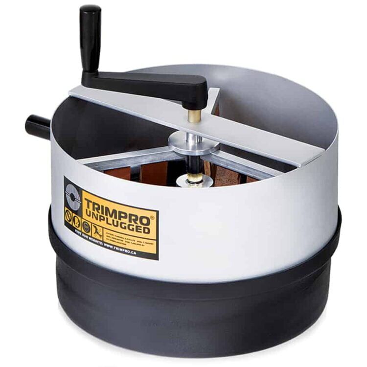 En trådløs, kompakt klipper præsenterer sig med en mat sort overflade og en ergonomisk, buet håndtag. Klipperens skærehoved er af metal, med skarpe tænder og en blank finish, der reflekterer lys. Knappen til tænd/sluk er placeret på siden, omgivet af et enkelt, funktionelt design. En rød indikator viser batteristatus, der tilføjer et farveelement.