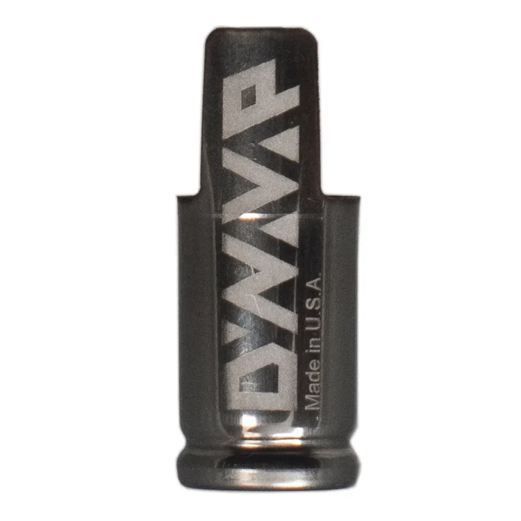 Det centrale objekt er en lille, cylindrisk metalcap med en børstet overflade, der reflekterer lys. Den har en perforeret struktur, hvilket skaber et unikt mønster. Kanten er let bøjet, hvilket giver en ergonomisk form. Cap’en har en mørk, næsten sort nuance, der kontrasterer med de lysere områder, hvor refleksionen fremhæver detaljerne.