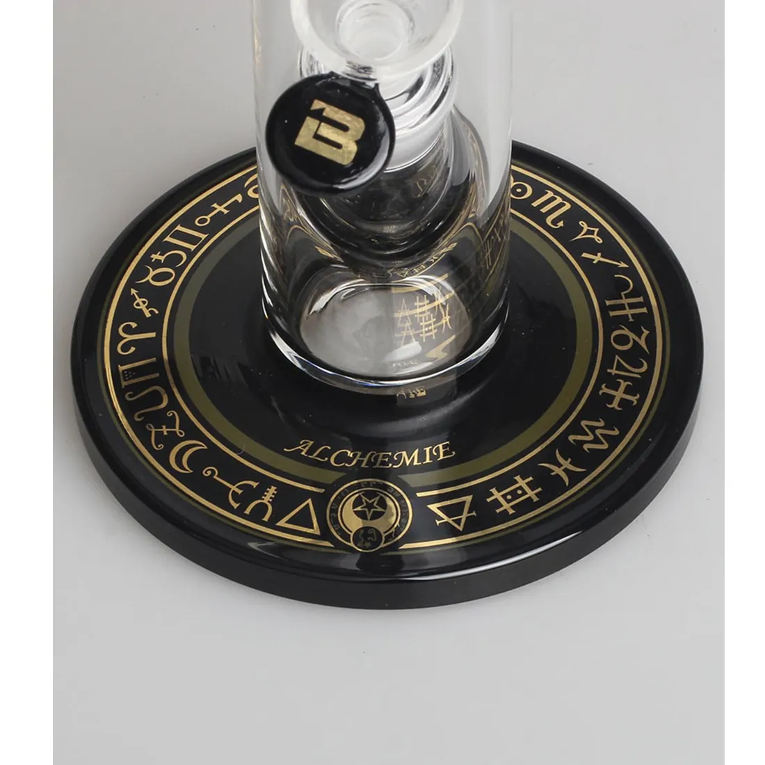 En høj bong i klart glas, der måler 48 cm. Den har en slank, cylindrisk form med en bred base og en smal hals. Bongen er dekoreret med farverige detaljer og en kompleks 10-armet perkolator, der forgrener sig i forskellige retninger. Bunddelen har en bred åbning til vand, og toppen er udstyret med en tilslutning til en skål.