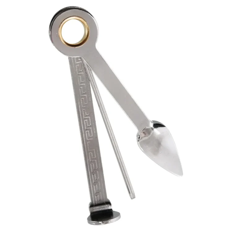 En metal 3-i-1 pibe renser præsenterer sig med et slankt, sølvfarvet design. Den har tre funktionelle ender: en skarp spids, en børste med fine børstehår og en flad skovl. Overfladen har en glat, blank finish, der reflekterer lys. Håndtaget er ergonomisk designet, hvilket giver et godt greb under brug.