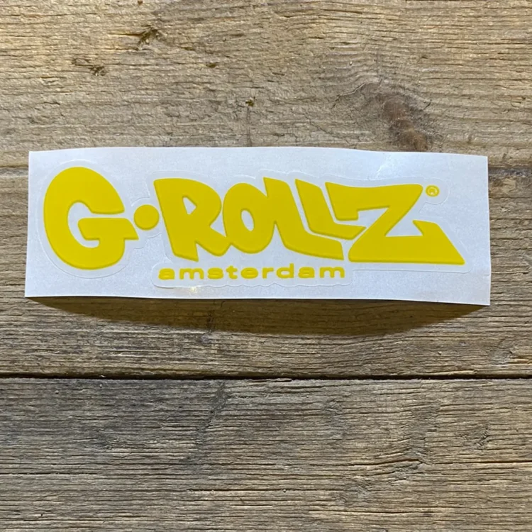 Logoet præsenterer sig i en lys gul farve med sort tekst. Det består af ordet "G-Rollz" i en moderne, sans-serif skrifttype, hvor bogstaverne er let afrundede. Baggrunden er ensfarvet, uden mønstre eller dekorationer, hvilket giver en ren og minimalistisk fremtoning. Logoets design er enkelt og letlæseligt, hvilket fremhæver navnets karakter.