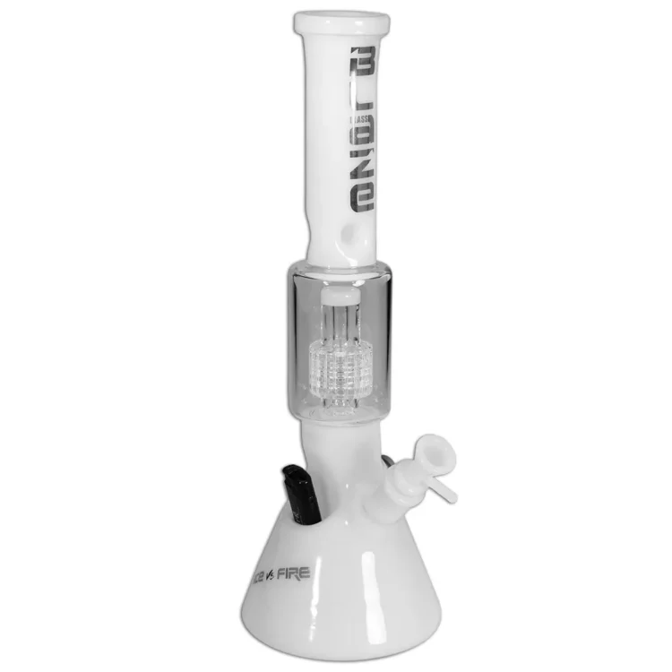 Glasvase med en høj, slank form og en hvid, glat overflade. Den har en prisme-lignende struktur med indviklede perkolatorer indeni, der skaber et spil af lys og skygger. Der ses en klar, åben top og en solid bund. Mønsteret i perkolatoren giver en kompleksitet til det transparente glas, der skaber en visuel dybde.