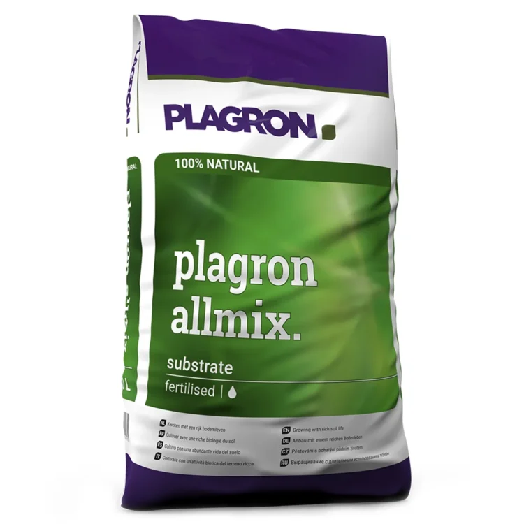 Brunlig pottemuld med en let grov tekstur, der indeholder små stykker af organisk materiale. Massen er ensartet og består af fine og grove partikler, som skaber en luftfyldt struktur. Der ses små brune og grønne spidser af tørrede planter, der tilfører dybde. Overfladen er jævn, og farven varierer fra mørkebrun til lysere nuancer.