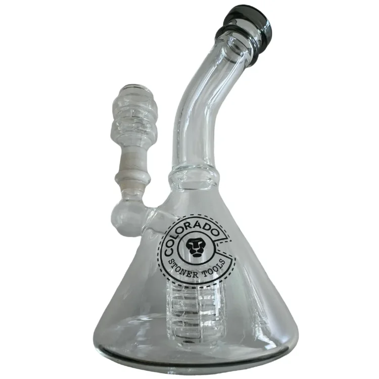 En miniaturemodel af en olieboringsplatform i mørkegrå og lysegrå nuancer pryder en stabil base. Platformens struktur omfatter vertikale søjler, der støtter en rektangulær overbygning, samt detaljerede elementer som rør og ventiler. Et par små, cirkulære lys er placeret øverst, mens platformens overflade har en glat, mat tekstur. Størrelsen er kompakt, ideel til udstilling.