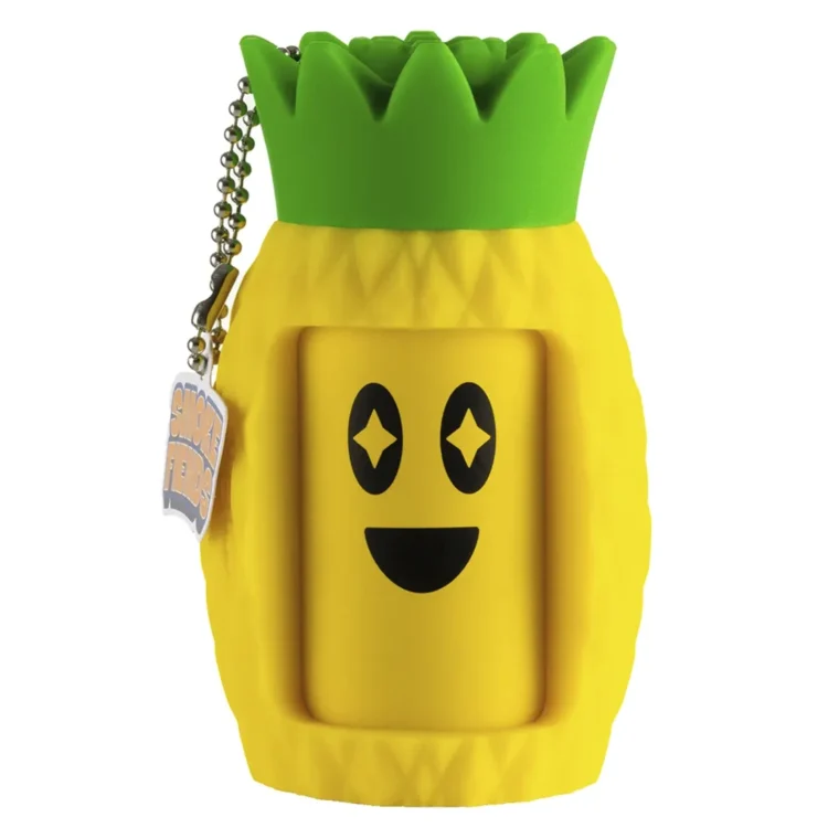 En ananasformet enhed pryder en grøn baggrund, fremstillet af et blødt, mat materiale med en let struktureret overflade. Farven er en lys, solrig gul med tydelige, grønne blade, der strækker sig opad. Enheden har et enkelt design uden synlige knapper eller symboler, hvilket giver et minimalistisk udtryk. Det samlede udseende er friskt og indbydende.