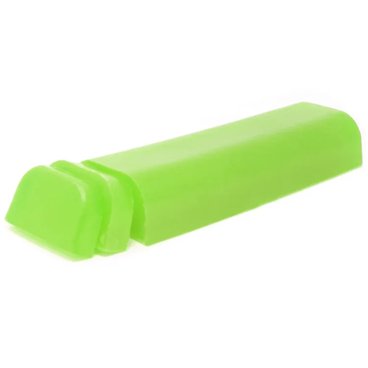 En shampoo bar med en oval form præsenterer sig i en lys grøn farve, der minder om friske urter. Overfladen har en let struktureret tekstur, der skaber en naturlig fornemmelse. Der er ingen synlige emballager, og baren er placeret på en neutral overflade, der fremhæver dens enkle og rustikke udseende.