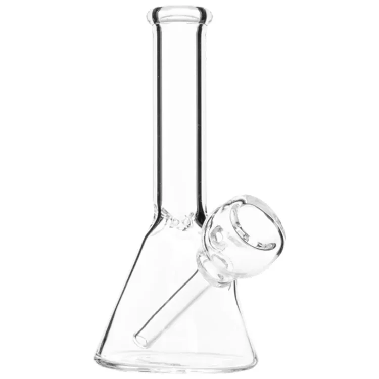 En mini beaker bong i klart glas med en højde på 12 cm. Beholderen har en bred, stabil base og en smal hals, der afsluttes med en udluftningsåbning. Den er udstyret med en indbygget perkolator og en lille skål til urter. Overfladen er glat, og der ses fine detaljer i form af afskårne kanter og en let krumning.