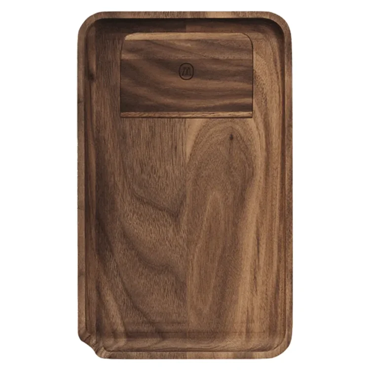 En rektangulær bakke i lys, naturlig træfarve pryder overfladen. Det glatte træ har synlige åretegninger og en let mat finish, der fremhæver materialets tekstur. Kanterne er let opadbuede, hvilket skaber en subtil ramme. Bakken har en enkel, funktionel form uden ekstra dekorationer, hvilket giver et minimalistisk udtryk.