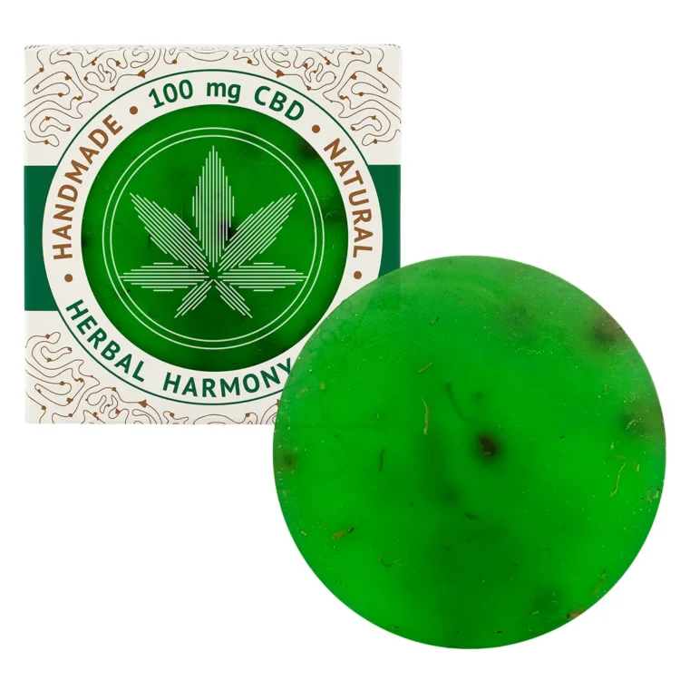 En firkantet sæbe i en naturlig, uregelmæssig form har en lys, grønlig farve med små, mørkere grønne partikler, der skaber en struktureret overflade. Den har en glat tekstur og er forsynet med en let skinnende finish. På overfladen er der indgraveret et mønster, der tilføjer visuel interesse. Sæben vejer 110 gram og har en simpel, naturlig æstetik.