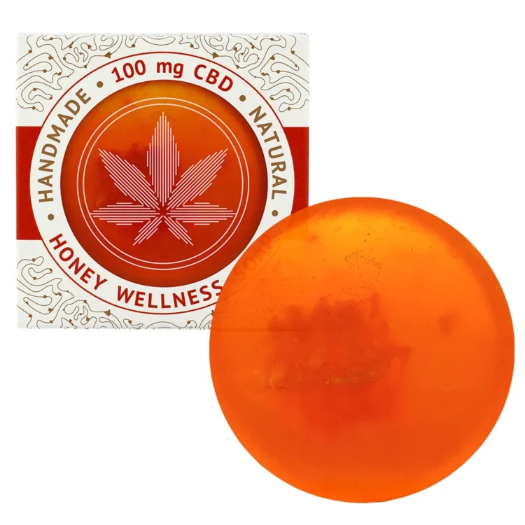 En firkantet sæbe med en glat, lys beige overflade og en let skinnende finish. Overfladen prydes af et mønster med fine, bølgede linjer og små indtryk, der giver en struktureret tekstur. Sæbens kanter er let afrundede. På forsiden er der indgraveret en tekst, som angiver produktets navn og vægt.